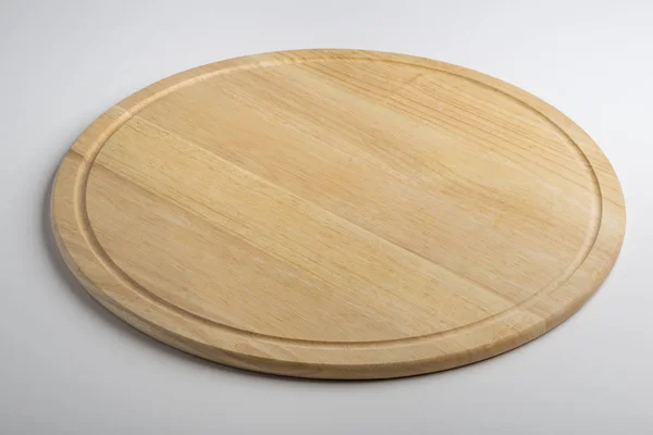 Isolated empty round wooden chopping board on white background