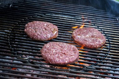 Üç hamburger ızgarada pişirme