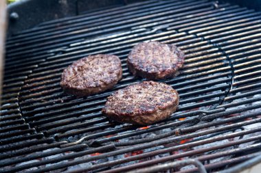 Üç hamburger ızgarada pişirme
