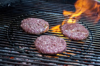 Üç hamburger ızgarada pişirme