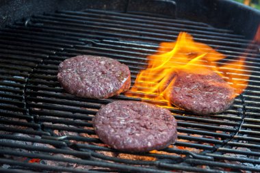 Üç hamburger ızgarada pişirme