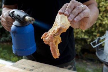 Tavuk kanadı bir meşale ile yanan tüyleri