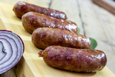 Kurulu ile dört ızgara sosis rustik bir masada kesme.