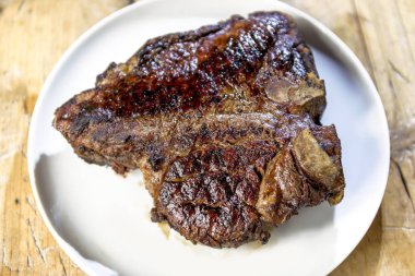 Ahşap masa üzerinde ızgara biftek sığır eti yuvarlak tabak