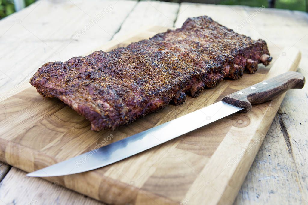 St Louis style grilled rack of pork ribs on cutting board