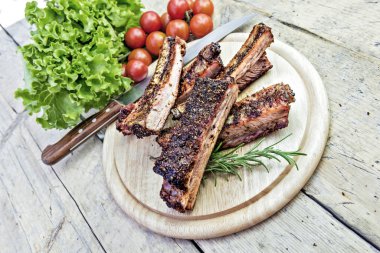 Izgara domuz pirzola domates ve salata ile yuvarlak kesme tahtası