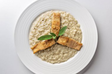Beyaz arka plan üzerinde izole Alabalık filetosu ile parmesan risotto yemek
