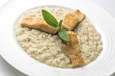 Beyaz arka plan üzerinde izole Alabalık filetosu ile parmesan risotto yemek