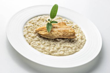 Beyaz arka plan üzerinde izole Alabalık filetosu ile parmesan risotto yemek