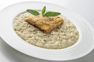 Beyaz arka plan üzerinde izole Alabalık filetosu ile parmesan risotto yemek