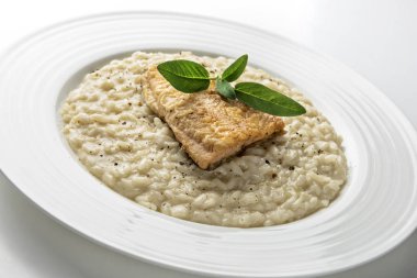 Beyaz arka plan üzerinde izole Alabalık filetosu ile parmesan risotto yemek