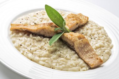 Beyaz arka plan üzerinde izole Alabalık filetosu ile parmesan risotto yemek