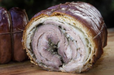 Doğrama Kurulu üzerinde yarım kesilmiş Rulo domuz eti Porchetta kavrulmuş