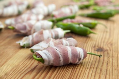 Hazırlık biber kıyılmış et ve peynir ile doldurulmuş ve kesme tahtası üzerinde pastırma kaplı