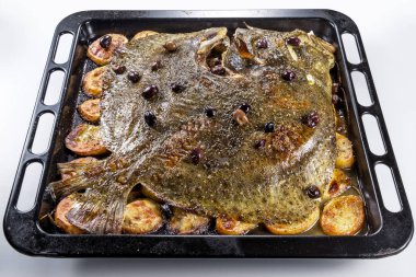 Patates zeytin ve beyaz arka plan üzerinde izole aromatik otlar ile tava fırın pişirme içinde pişmiş bütün kalkan balığı
