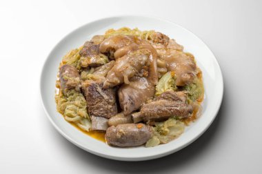 Domuz eti ve savoy lahana ile beyaz tabak
