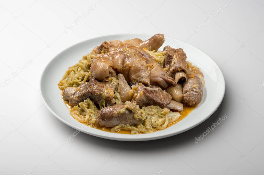 White plate with pork meat and savoy cabbage