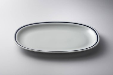 Kenarında mavi çizgi olan beyaz oval plaka.