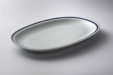 Kenarında mavi çizgi olan beyaz oval plaka.