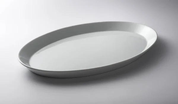 Изолированная белая овальная тарелка — стоковое фото