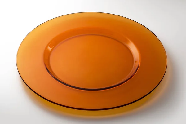 Кругла помаранчева плоска тарілка в прозорому кристалі — стокове фото