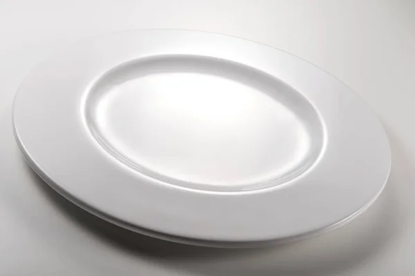 Placă albă rotundă goală pe masă albă — Fotografie, imagine de stoc