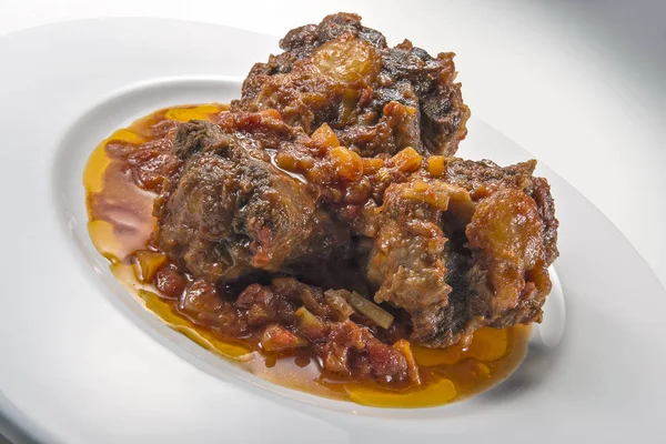 Isolated Dish with a portion of oxtail stewed vaccinara — Stock Image Isolated Dish with a portion of oxtail stewed vaccinara Stock Image