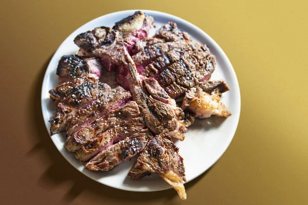 Piatto rotondo bianco con bistecca di T-bone tagliata alla griglia — Foto Stock
