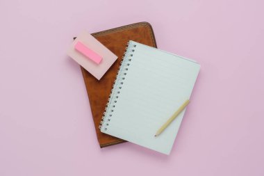 Tablo üstten görünüm Eğitim sezonu arka plan kavramının okula geri hava görüntüsü. Günlük Not kuytu ile yat ve modern rustik pembe kağıt üzerinde kalem. Yaratıcı tasarım kadar alay etmek için boş alan.