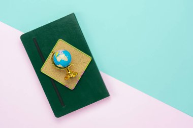 Tablo üstten görünüm küresel dünya arka plan kavramı, eğitim mevsiminde okula geri hava görüntüsü. Düz lay Not köşe modern nedeniyle sesi yeşil ve pembe kağıt üzerinde olan dünya küre modeli harita daire.