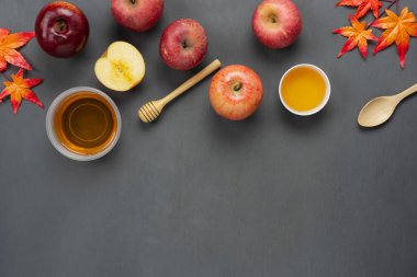 Tablo üstten görünüm süslemeleri Yahudi tatil Rosh Hashana arka plan kavramı hava görüntüsü. Çeşitli elma ve bal akçaağaç yaprağı modern rustik gri Wood ile düz lay. Tasarım metin için boş alan.