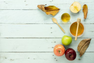 Masa üstü Rosh Hashana arka plan kavramı süslemeleri Yahudi tatil hava görüntüsünü görüntüleyin. Düz çeşitli elma ve bal arı nesne iz Kupası ve tahta kaşık modern rustik yeşil ahşap duvar üzerinde yatıyordu.