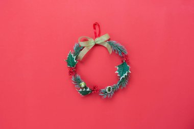 Merry Christmas dekorasyon ve mutlu yeni yıl süsleme kavramı masa üst görünümünü. Düz temel fark nesneleri dekor çelenk köknar ağacı kırmızı kağıt modern arka plan üzerinde yatıyordu. Tasarım kadar sahte ve şablon