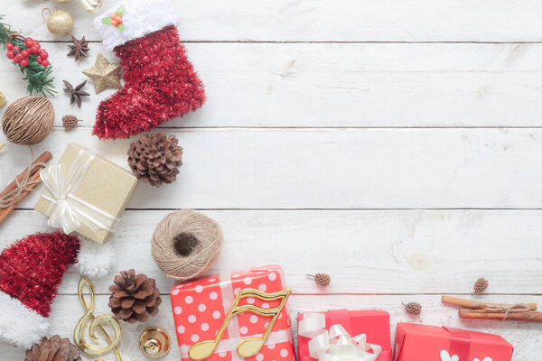 Above view of Merry Christmas decorations & Happy new year ornaments concept.Essential difference objects on modern rustic wood white background at home studio office desk.Party items on floor.