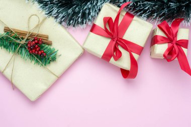 Merry Christmas dekorasyon ve mutlu yeni yıl süsleri kavramı en iyi görünümünü masa. Düz yatıyordu temel fark nesneleri hediye kutusu ve köknar ağacı ev stüdyosu ofis masası, pembe kağıt modern arka plan üzerinde.