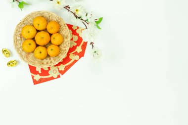 Çince dil demek zengin ya da zengin ve mutlu. Ay yeni yıl ve Çin yeni yıl tatili arka plan üzerinde tablo üstten görünüm aksesuarları. Turuncu ve kırmızı harçlık ve modern kahverengi ahşap üzerine kiraz çiçeği