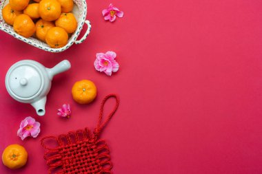 Çince dil demek zengin ya da zengin ve mutlu. Tablo üstten görünüm ay yeni yıl ve Çince yeni yıl kavramı arka plan. Düz yatıyordu turuncu ve kırmızı kağıt üzerinde çiçek ve servet sezon süslemeleri ile fincan çay.