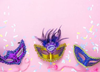 Tablo en iyi görünüm güzel renkli karnaval festival arka plan hava görüntüsü. Ev ofis resepsiyon studio.copy alan pembe kağıt modern düz aksesuar nesne birkaç maskesi ve dekor konfeti lay.