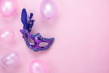 Tablo üstten görünüm hava güzel renkli süslemeleri Mardi Gras ya da görüntü karnaval festival arka plan. Düz aksesuar nesneleri maske ve dekor mor ve pembe balon modern pembe kağıt üzerinde yatıyordu..