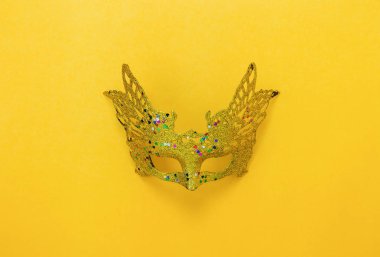 Tablo üstten görünüm havadan görüntü güzel renkli Karnaval sezonu veya photo booth pervane Mardi Gras arka plan. Modern sarı duvar kağıdı düz yatıyordu nesne altın maske. Yaratıcı tasarım sahte için boş alan