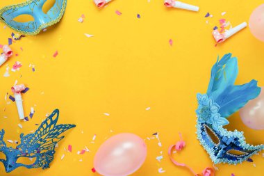 Tablo en iyi görünüm güzel renkli karnaval festival arka plan hava görüntüsü. Düz aksesuar nesne maske ve dekor konfeti ve balon modern sarı kağıt üzerinde ev ofis resepsiyon stüdyoda yatıyordu.