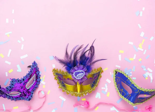 Tablo en iyi görünüm güzel renkli karnaval festival arka plan hava görüntüsü. Ev ofis resepsiyon studio.copy alan pembe kağıt modern düz aksesuar nesne birkaç maskesi ve dekor konfeti lay.