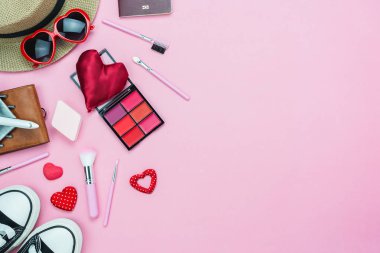 Tablo üstten görünüm dekorasyon Sevgililer günü arka plan kavramı hava görüntüsü. Seyahat için düz yatıyordu temel öğeleri uçak. Giyim kadın ve gezgin için kozmetik ile pembe kağıt üzerinde kırmızı kalp ve Hediyelik kutu.