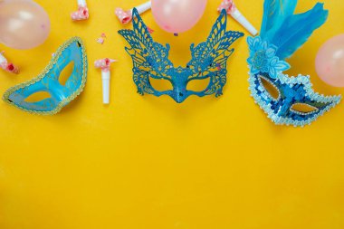 Tablo üstten görünüm havadan görüntü güzel renkli karnaval sezonu veya photo booth pervane Mardi Gras arka plan. Dekorasyon ve konfeti ve pembe balon sarı duvar kağıdı ile düz yatıyordu nesne mavi maske.
