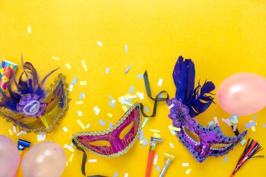 Tablo üstten görünüm havadan görüntü güzel renkli karnaval sezonu veya photo booth pervane Mardi Gras arka plan. Dekorasyon ve konfeti ve pembe balon sarı duvar kağıdı ile düz yatıyordu çeşitli maske.