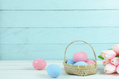 Dekorasyon mutlu Paskalya tatili arka plan kavramı bir kadeh. Düzenleme bunny yumurta ahşap sepet ve Lale üzerinde beyaz ve mavi rustik ahşap evde Ofis Masası masa. Creative için negatif boşluk.