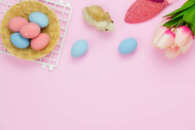 Tablo üstten görünüm süslemeleri mutlu Paskalya tatili arka plan kavramı bir kadeh. Düz yatıyordu bunny yumurta ve Lale ve tavşan bebek stüdyo Ofis Masası, pembe kağıt üzerinde. Boş alan Tasarım sahte için yukarı ve şablon.