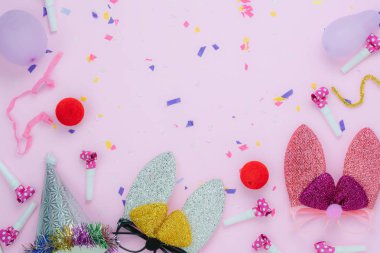 Tablo üstten görünüm süslemeleri mutlu Paskalya tatil veya karnaval parti festival arka plan kavramı bir kadeh. Düz metin için modern rustik pembe paper.space üzerine konfeti ile kulak veya maske ve nesneleri bunny göklere.