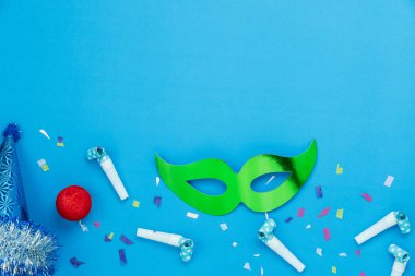 Tablo üstten görünüm havadan görüntü güzel renkli karnaval sezonu veya photo booth pervane Mardi Gras arka plan. Dekorasyon ve parti ve kopya alanı için mavi kağıt üzerine konfeti ile düz yatıyordu renkli maskesi.