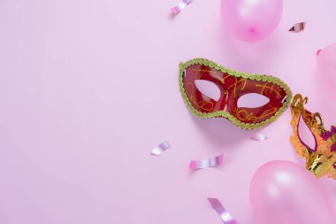 Tablo üstten görünüm havadan görüntü güzel renkli karnaval sezonu veya photo booth pervane Mardi Gras arka plan. Düz yatıyordu nesne renkli maskesi ile dekorasyon ve konfeti ve balon pembe kağıt üzerinde.